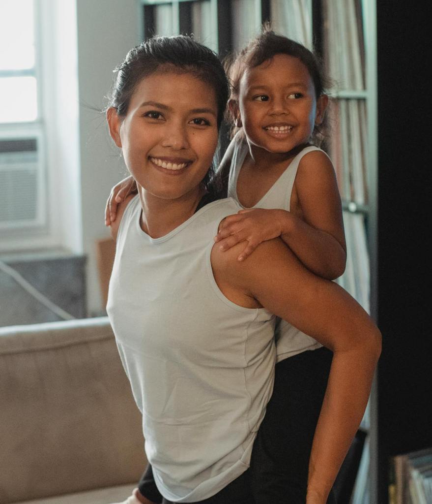 happy girl riding piggyback on mother